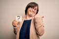 Young down syndrome business woman holding question mark paper as doubt symbol very happy pointing with hand and finger to the Royalty Free Stock Photo