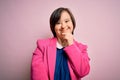 Young down syndrome business woman over pink background looking confident at the camera with smile with crossed arms and hand Royalty Free Stock Photo