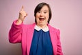 Young down syndrome business woman over pink background pointing finger up with successful idea Royalty Free Stock Photo
