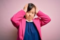 Young down syndrome business woman over pink background suffering from headache desperate and stressed because pain and migraine Royalty Free Stock Photo