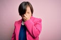 Young down syndrome business woman over pink background tired rubbing nose and eyes feeling fatigue and headache Royalty Free Stock Photo