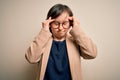 Young down syndrome business woman wearing glasses standing over isolated background with hand on head for pain in head because Royalty Free Stock Photo