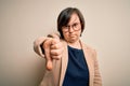 Young down syndrome business woman wearing glasses standing over isolated background looking unhappy and angry showing rejection Royalty Free Stock Photo