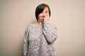 Young down syndrome woman standing over isolated background looking stressed and nervous with hands on mouth biting nails Royalty Free Stock Photo