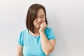 Young down syndrome woman standing over isolated background looking stressed and nervous with hands on mouth biting nails Royalty Free Stock Photo