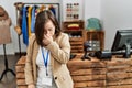 Young down syndrome woman working as manager at retail boutique tired rubbing nose and eyes feeling fatigue and headache Royalty Free Stock Photo