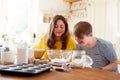 Young Downs Syndrome Couple Baking In Kitchen At Home