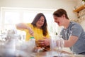 Young Downs Syndrome Couple Baking In Kitchen At Home