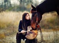 Young dreadded girl with her horse and shamanic frame drum. Royalty Free Stock Photo