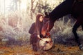 Young dreadded girl with her horse and shamanic frame drum. Royalty Free Stock Photo