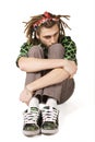 Young dreadlock man sits isolated