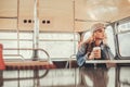 Young dreamful lady drinking coffee in bus cafe