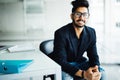 Young dreamy indian businessman in suit thinking of business vision outlook planning future project idea at work with laptop, succ Royalty Free Stock Photo
