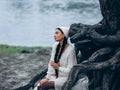 Young dreamy woman with closed eyes sitting and resting in forest near trunk tree Royalty Free Stock Photo