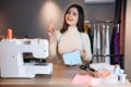 Young dressmaker woman sews clothes on sewing machine. Dreaming and creating seamstress in workshop. Creating online Royalty Free Stock Photo