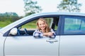 Young driver looking out of the car window holding a key Royalty Free Stock Photo