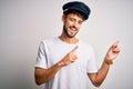 Young driver man with beard wearing hat standing over isolated white background smiling and looking at the camera pointing with Royalty Free Stock Photo
