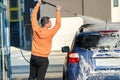 Young driver man washing his car with contactless high pressure water jet in self service car wash Royalty Free Stock Photo