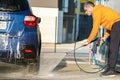 Young driver man washing his car with contactless high pressure water jet in self service car wash Royalty Free Stock Photo