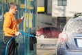 Young driver man washing his car with contactless high pressure water jet in self service car wash Royalty Free Stock Photo