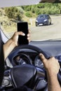 Young driver, using smartphone, on the road in the car Royalty Free Stock Photo