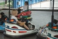 Young drivers having fun at children playground on go kart race. Children driving bumper car in the amusement park
