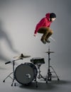 Young drummer jumping while playing