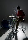 Young drummer playing in the contre light