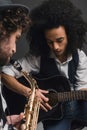 young duet of musicians playing sax and acoustic guitar