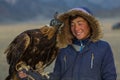 Young Eagle Hunter traditional clothing, while hunting to the hare holding a golden eagle on his arm in desert mountain