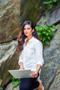 Young East Indian American Woman with long hair working on laptop computer outdoor in New York
