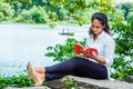 Young East Indian American Woman reading red book, relaxing at Central Park, New York