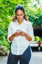 Young East Indian American Woman texting on cell phone outdoor at Central Park, New York Royalty Free Stock Photo