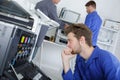 Young efficient engineer working on printer and adjusting components Royalty Free Stock Photo