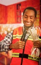 Young electrical worker wearing safety vest, holding cables and cable pliars, smiling with great positive attitude