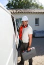 Young electrician artisan taking tools out of professional truck van Royalty Free Stock Photo