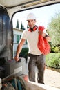 Young electrician artisan taking tools out of professional truck van