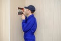 young electrician in blue overall disassembling a electrical panel with fuses in a house