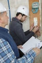 young electrician builder engineer screwing equipment in fuse box