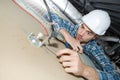 Young electrician fixing neon on ceiling