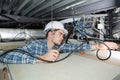 Young electrician fixing neon on ceiling