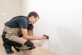 A young electrician installing an electrical socket in a new house. Royalty Free Stock Photo
