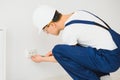 A young electrician installing an electrical socket in a new house Royalty Free Stock Photo