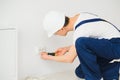 A young electrician installing an electrical socket in a new house Royalty Free Stock Photo