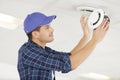 young electrician installing smoke detector on ceiling Royalty Free Stock Photo