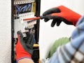 Young electrician technician at work on a electrical panel with