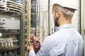 Young electrician working on electric panel. Electrician engineer tests electrical installations and wires on relay protection Royalty Free Stock Photo