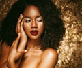 Young elegant african american woman with afro hair. Glamour makeup. Golden Background. Royalty Free Stock Photo