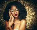 Young elegant african american woman with afro hair. Glamour makeup. Golden Background. Royalty Free Stock Photo