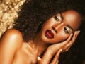 Young elegant african american woman with afro hair. Glamour makeup. Golden Background. Royalty Free Stock Photo